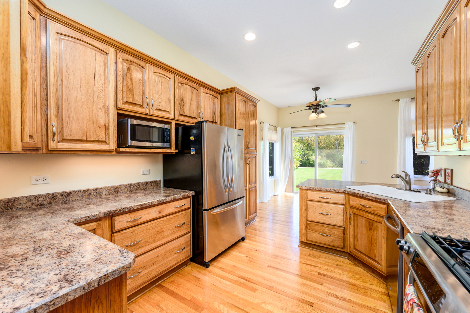 592 South Walnut Street Manteno, IL 60950 - Photo 15 of 37 a kitchen with stainless steel appliances granite countertop a refrigerator a stove and a sink with wooden floor