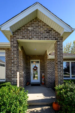 a view of a porch with a table and chairs in back of house