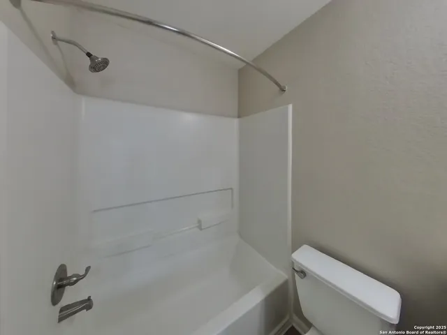 a white toilet and tub sitting next to a shower