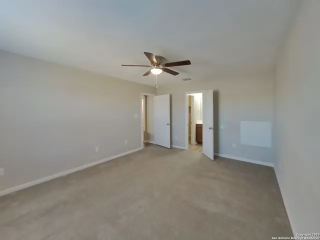 a view of an empty room with a ceiling fan
