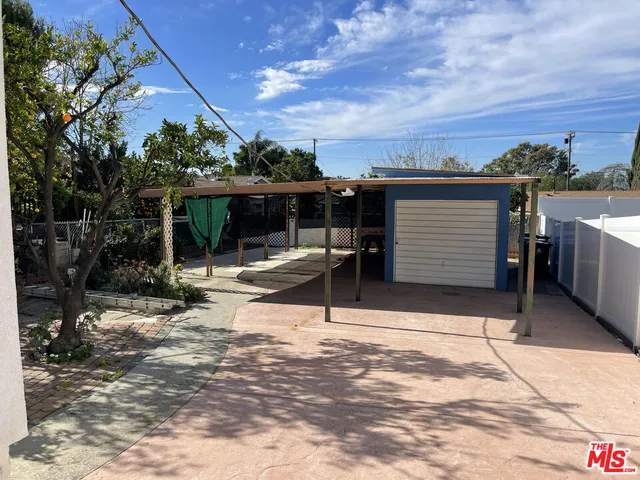 a view of a patio with a table and chairs and potted plants