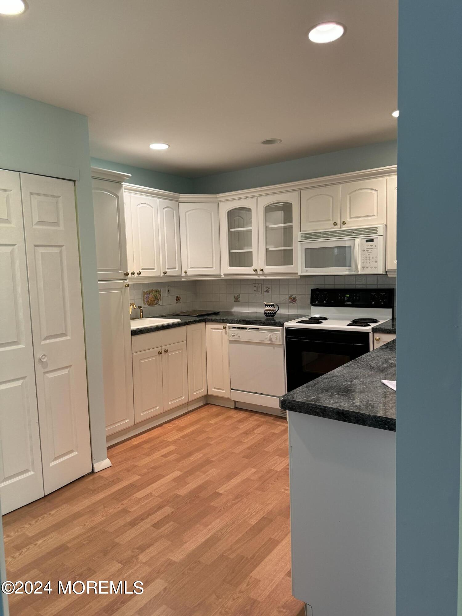 95 Lexington Court Red Bank, NJ 07701 - Photo 4 of 26 a kitchen with stainless steel appliances granite countertop a stove a sink and a microwave