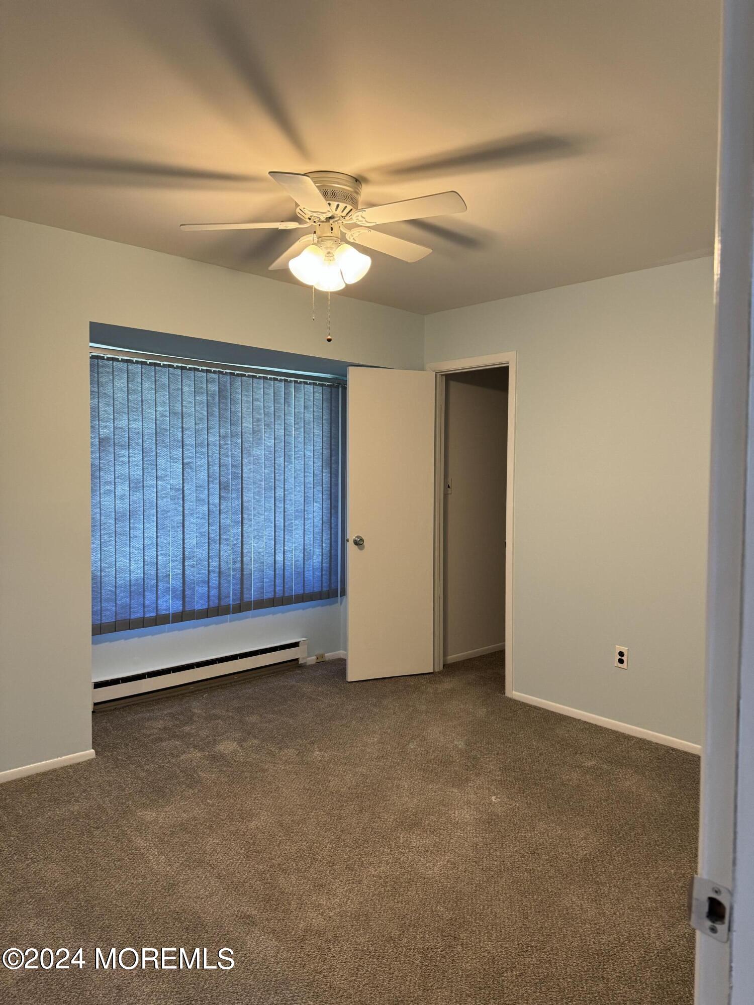 95 Lexington Court Red Bank, NJ 07701 - Photo 9 of 26 an empty room with a ceiling fan and a window