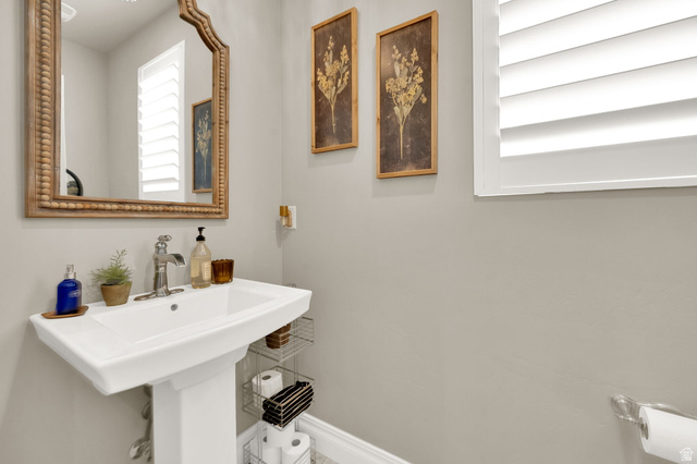 1132 South 1300th Street West Mapleton, UT 84664 - Photo 16 of 52 Pedestal sink with polished chrome faucet, framed by a decorative wooden mirror