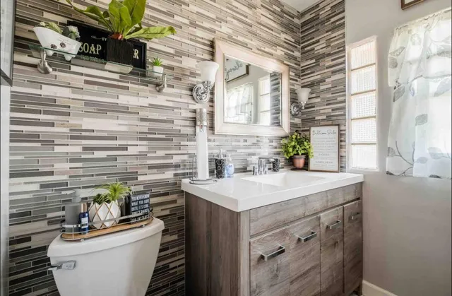a bathroom with a sink a toilet and mirror
