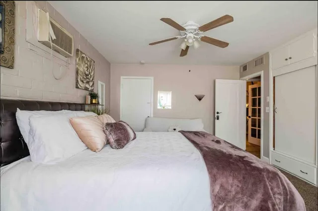 a bedroom with a large bed and a ceiling fan