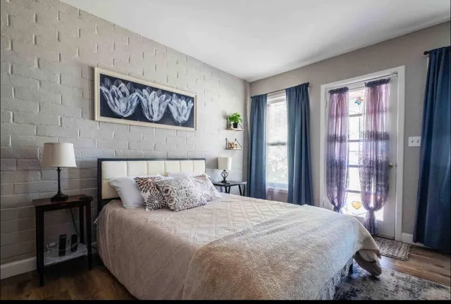 a bedroom with a bed and wooden floor