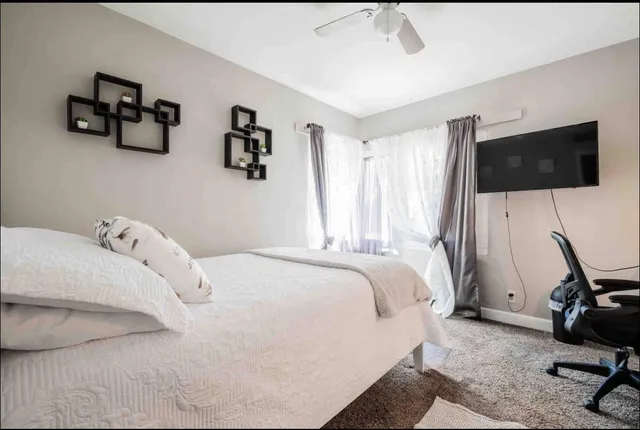 a bedroom with a bed and a flat screen tv