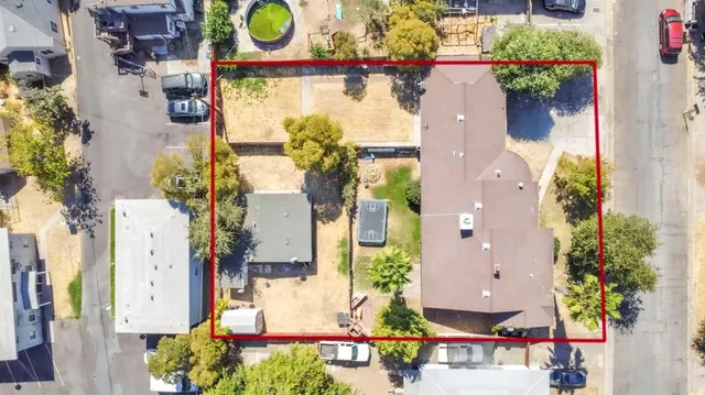 an aerial view of residential houses with outdoor space and parking
