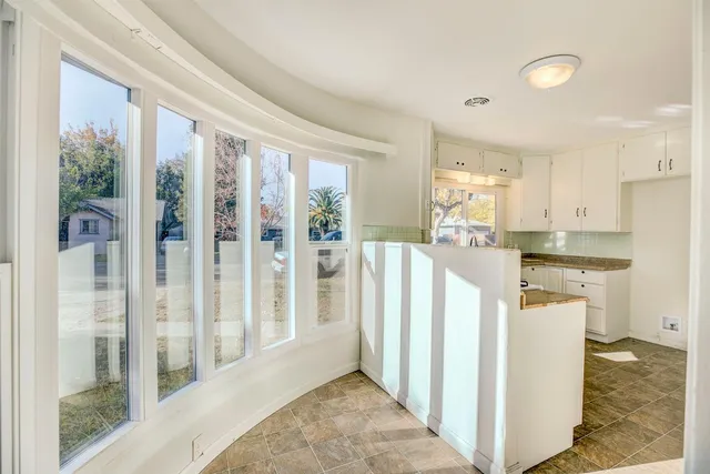 a open kitchen with white cabinets and wooden floor