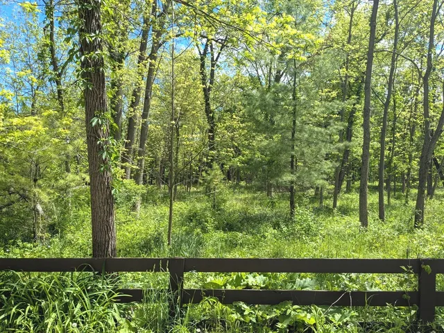 an aerial view of ocean with residential house with outdoor space and trees around