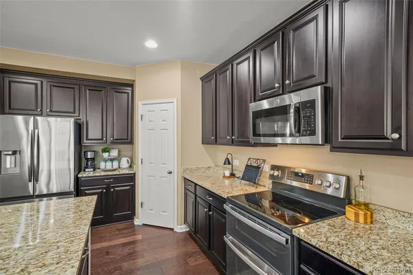 a kitchen with granite countertop stainless steel appliances and wooden cabinets