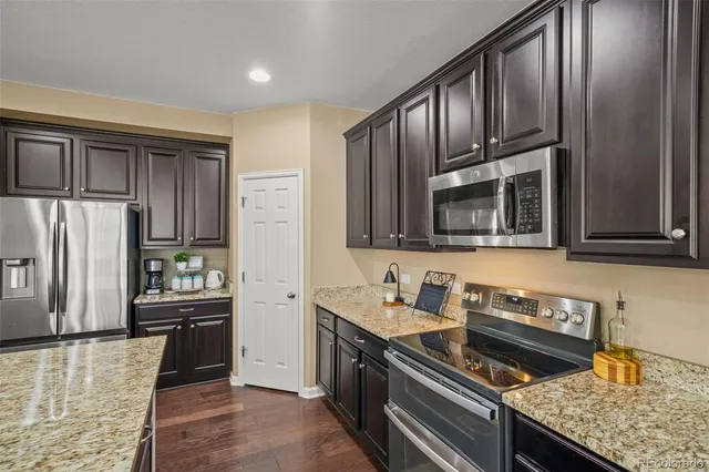 a kitchen with granite countertop stainless steel appliances and wooden cabinets