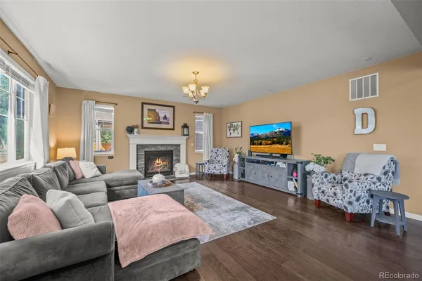 a living room with furniture a flat screen tv and a fireplace