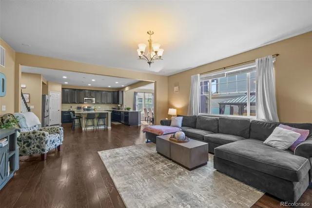 a living room with furniture wooden floor and a chandelier
