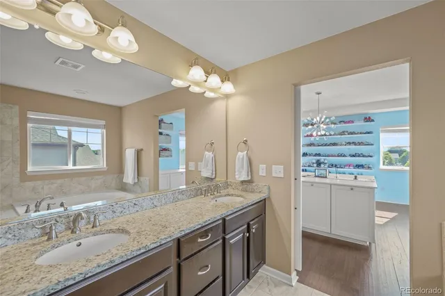 a bathroom with a granite countertop sink a large mirror and a shower