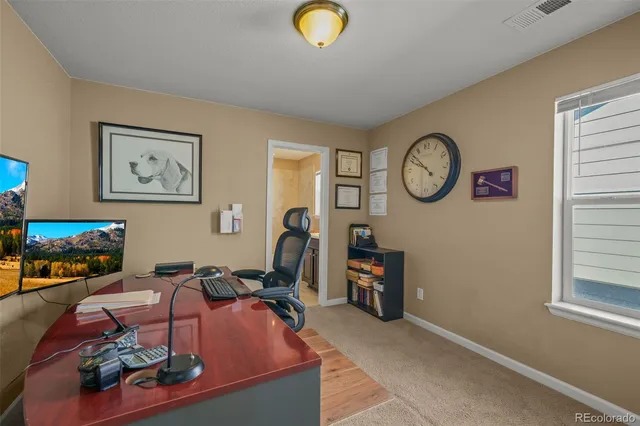 a living room with furniture a window and a clock