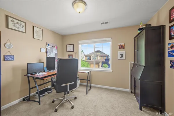 a view of a workspace with furniture and a window