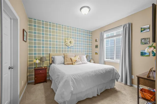 a bedroom with a bed and a flat tv screen next to a window