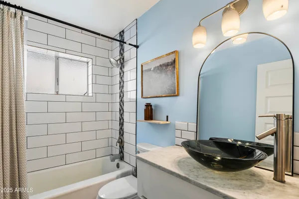 a bathroom with a granite countertop sink a toilet and bathtub