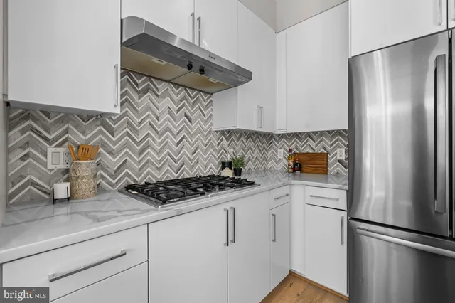 a kitchen with stainless steel appliances granite countertop a refrigerator and a stove