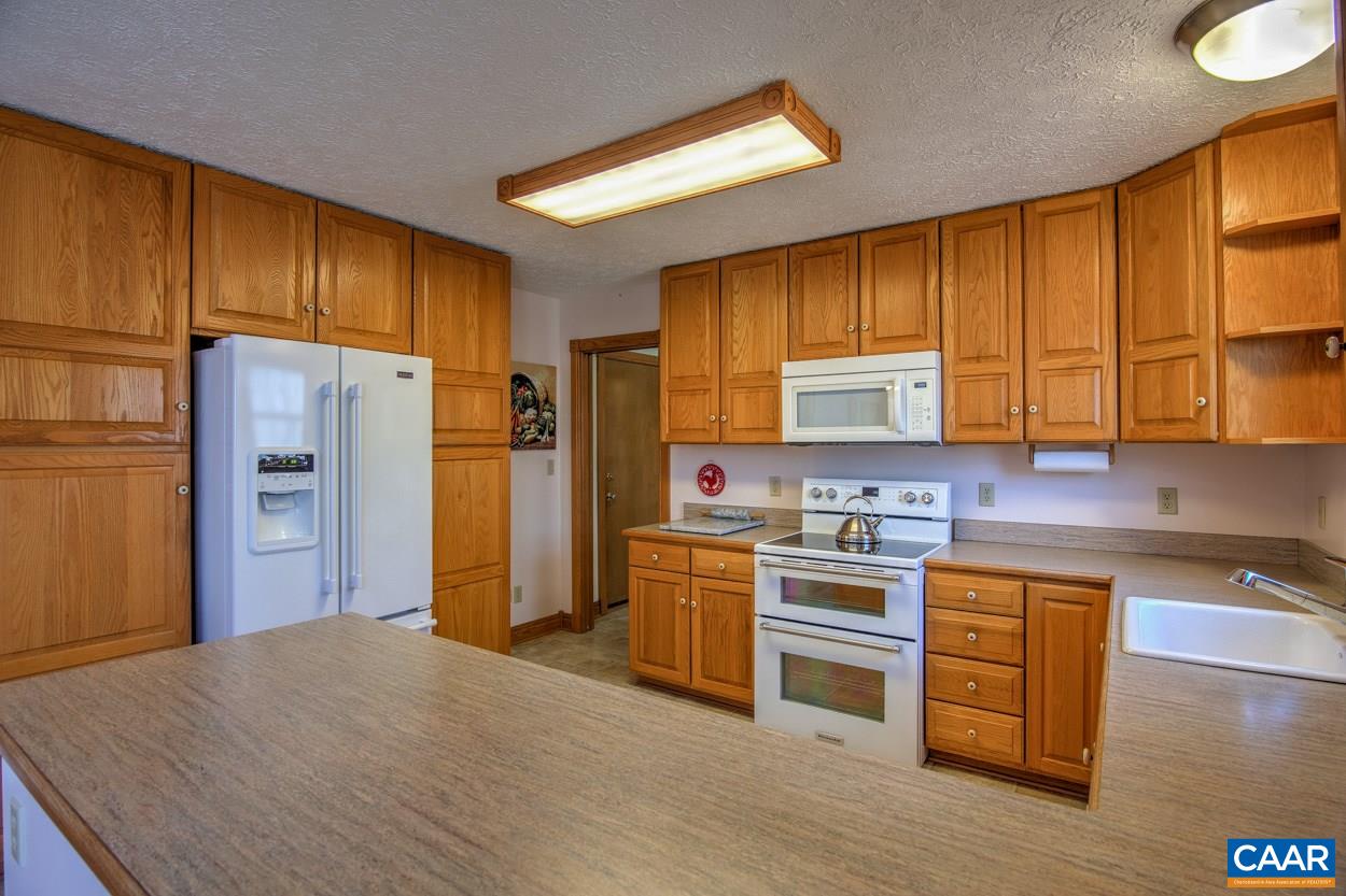 87 Laguna Road Palmyra, VA 22963 - Photo 4 of 38 a kitchen with stainless steel appliances granite countertop white cabinets a refrigerator a stove a sink and dishwasher with wooden floor