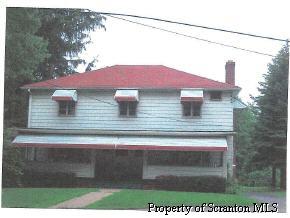 a view of a wooden house with a yard