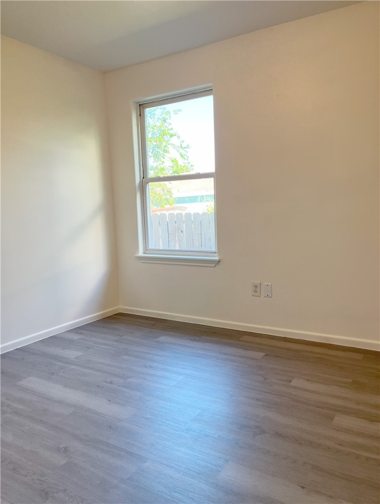 1802 16th Street, Unit B Corpus Christi, TX 78404 - Photo 11 of 17 an empty room with wooden floor and windows