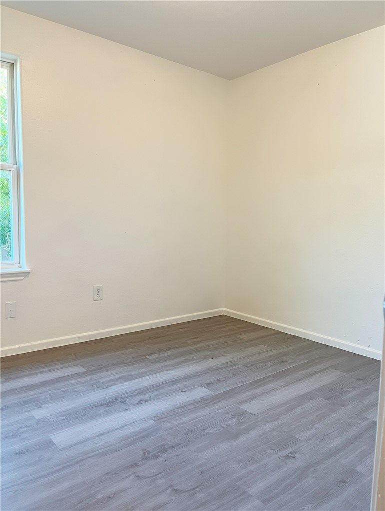 1802 16th Street, Unit B Corpus Christi, TX 78404 - Photo 15 of 17 a view of an empty room with wooden floor and a window