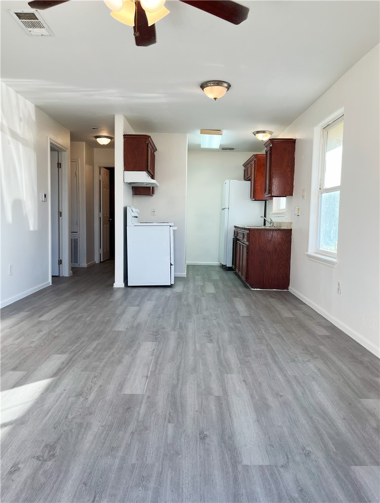 1802 16th Street, Unit B Corpus Christi, TX 78404 - Photo 3 of 17 a kitchen with stainless steel appliances kitchen island wooden floors granite counter tops and a window
