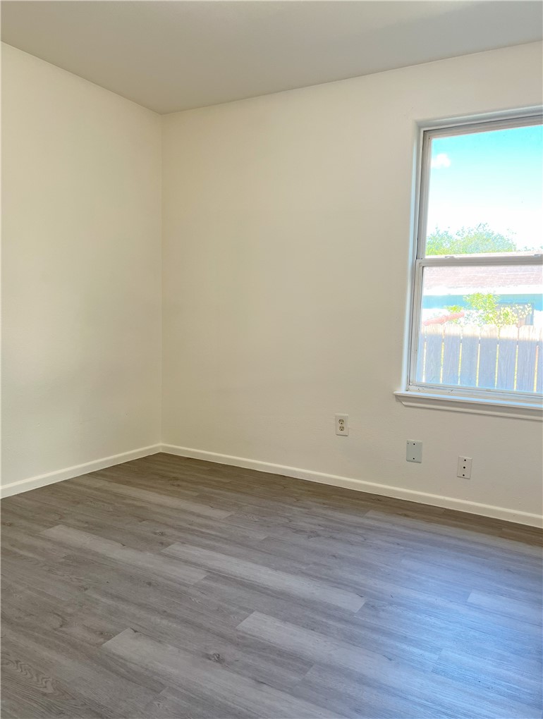 1802 16th Street, Unit B Corpus Christi, TX 78404 - Photo 8 of 17 a view of an empty room with wooden floor and a window