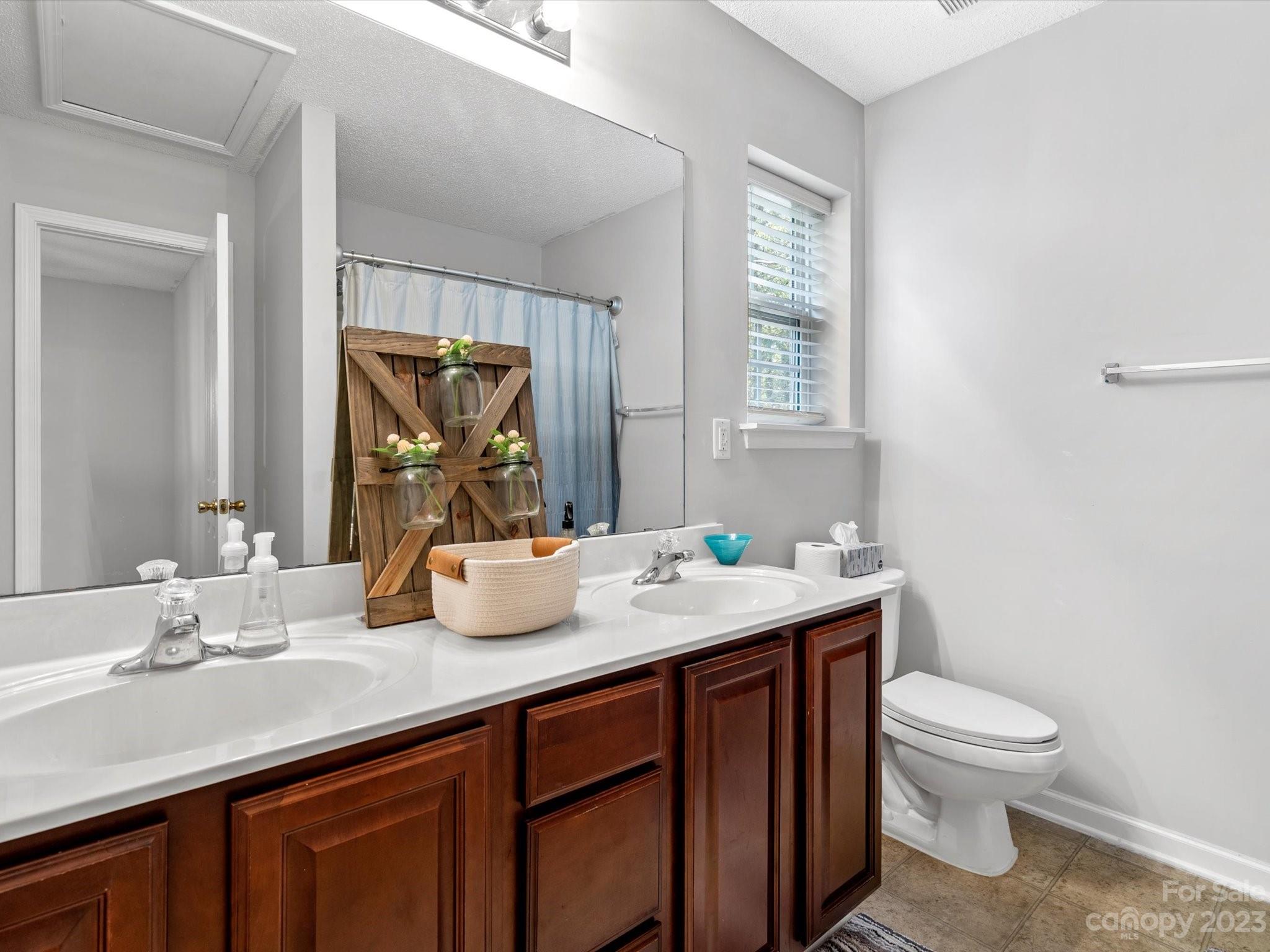 8162 Rudolph Road Charlotte, NC 28216 - Photo 11 of 17 a bathroom with a toilet sink and mirror