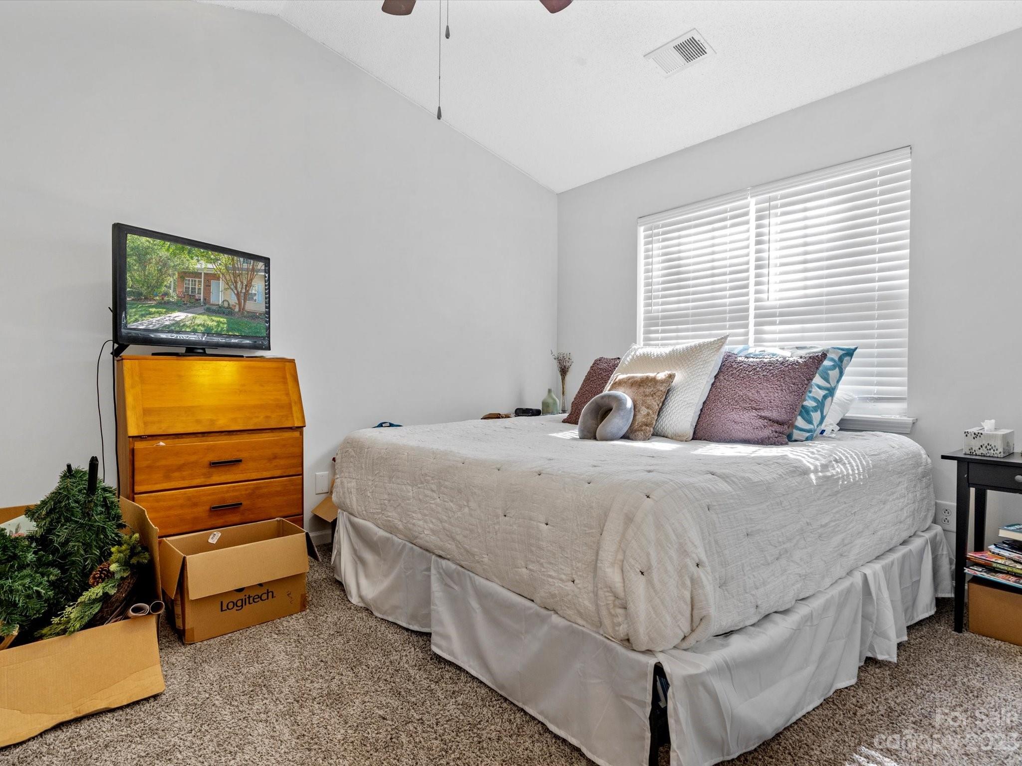 8162 Rudolph Road Charlotte, NC 28216 - Photo 13 of 17 a bedroom with a bed and a flat screen tv