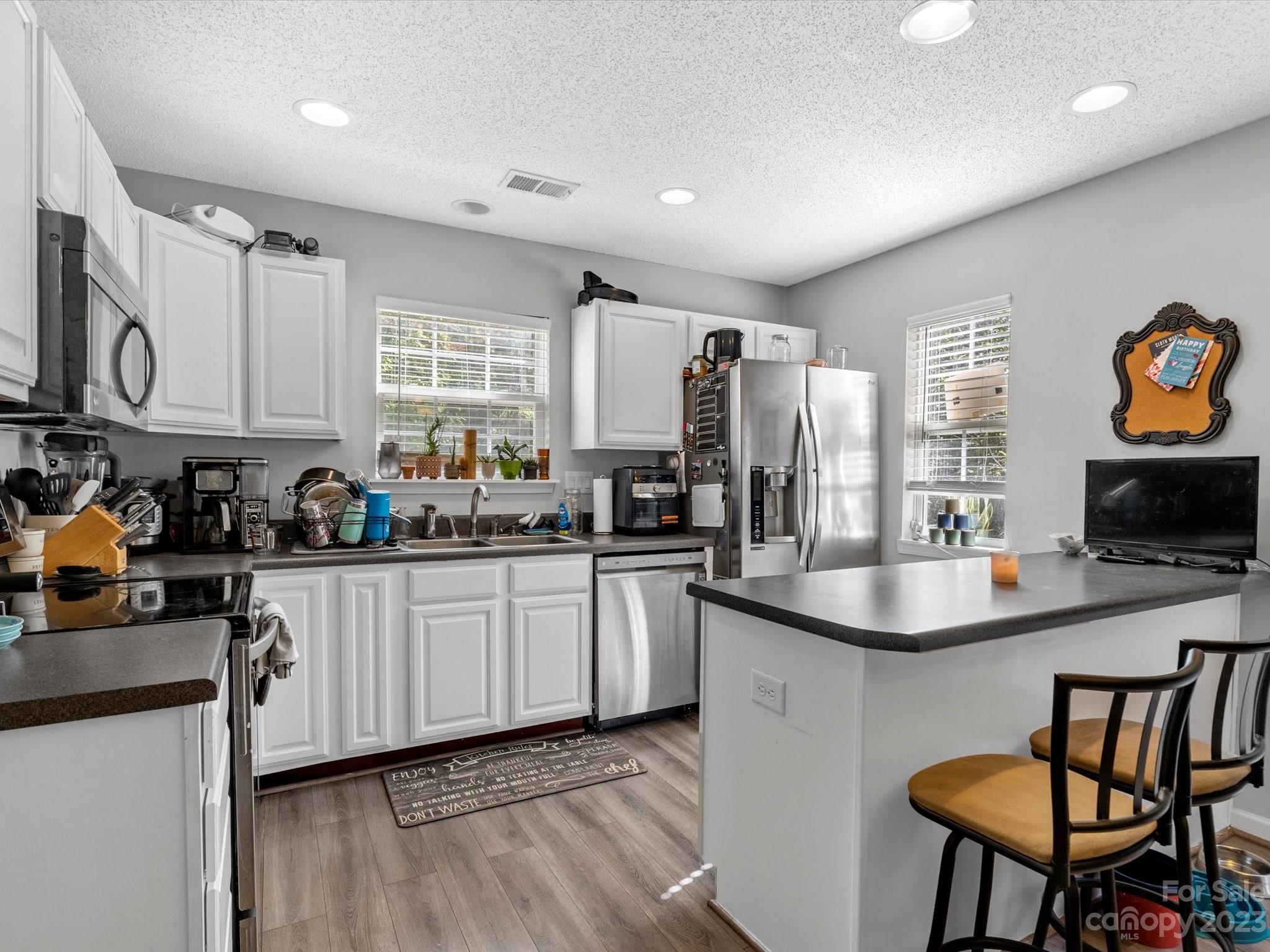 8162 Rudolph Road Charlotte, NC 28216 - Photo 8 of 17 a kitchen with stainless steel appliances granite countertop a sink a stove a refrigerator cabinets and dining table