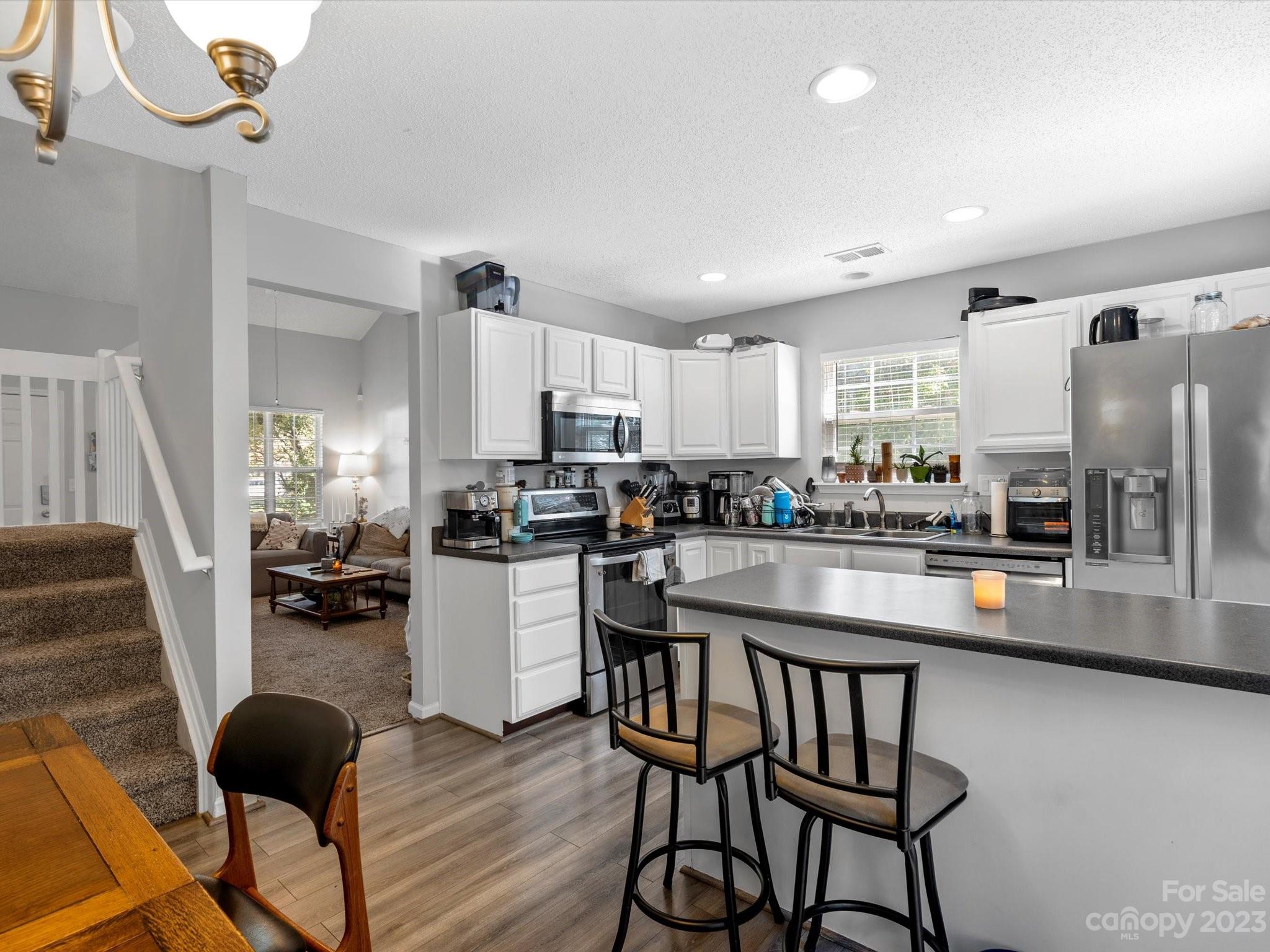 8162 Rudolph Road Charlotte, NC 28216 - Photo 10 of 17 a kitchen with stainless steel appliances granite countertop a table chairs refrigerator and microwave