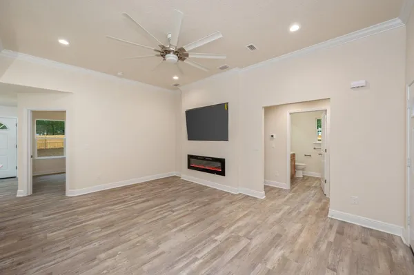 an empty room with wooden floor and ceiling fan