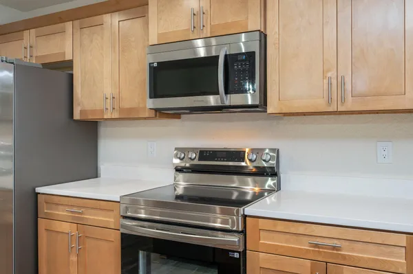 a kitchen with stainless steel appliances granite countertop a sink and a stove