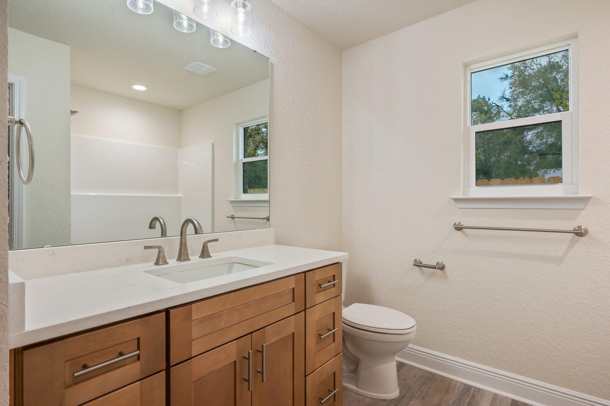609 East Chestnut Avenue Crestview, FL 32539 - Photo 21 of 31 a bathroom with a toilet a sink a vanity and mirror