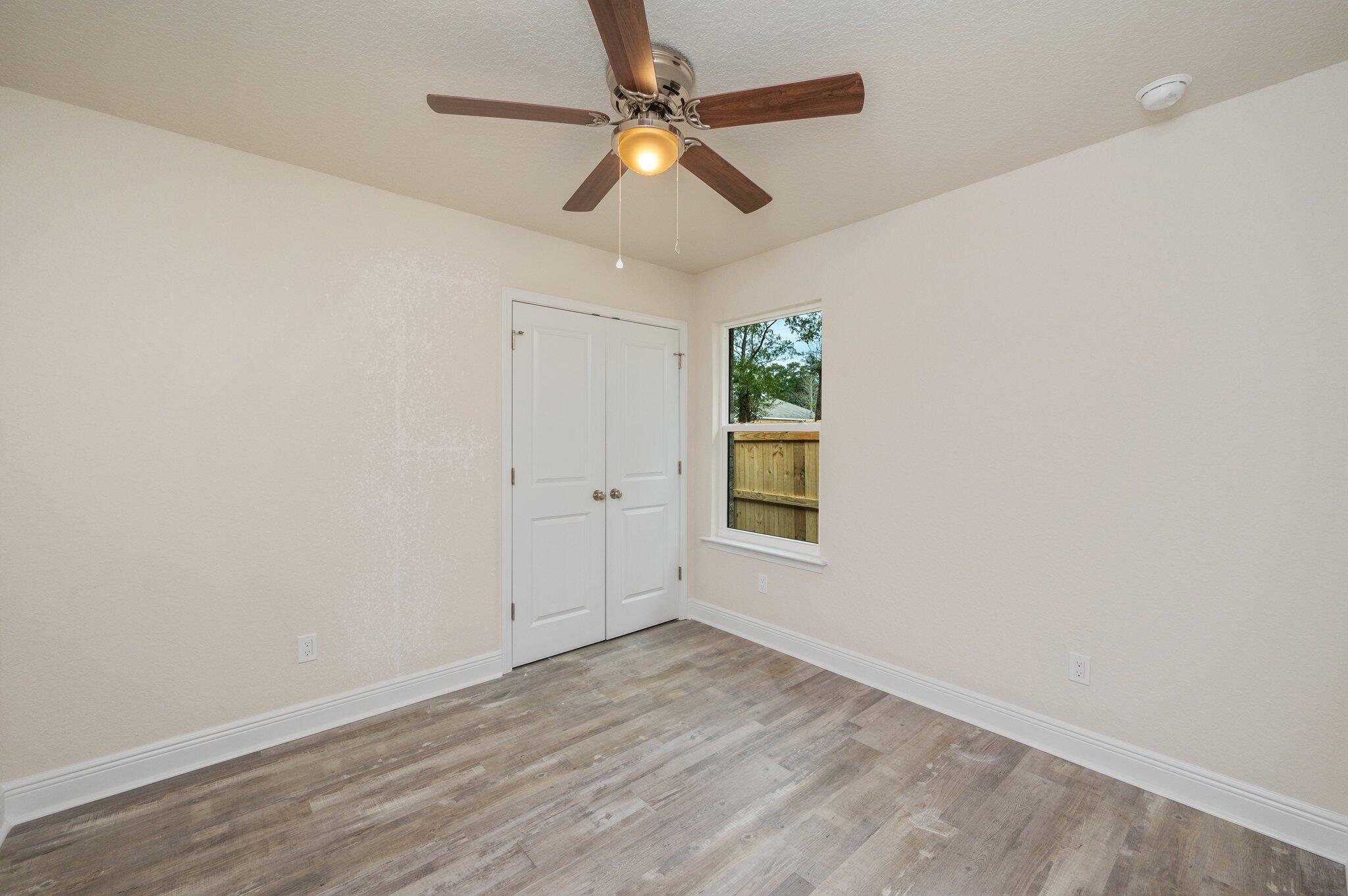 609 East Chestnut Avenue Crestview, FL 32539 - Photo 23 of 31 an empty room with a window and a ceiling fan