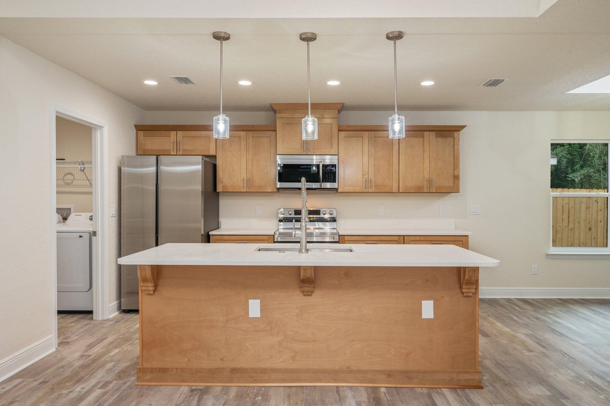 609 East Chestnut Avenue Crestview, FL 32539 - Photo 3 of 31 a view of a kitchen with kitchen island a counter top space stainless steel appliances and a ceiling fan