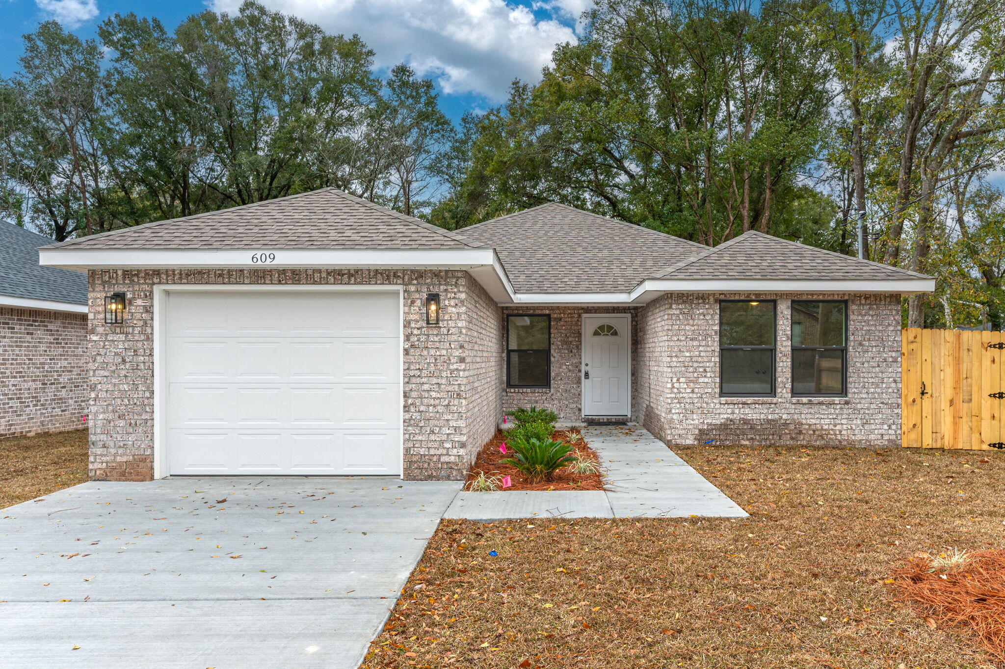 609 East Chestnut Avenue Crestview, FL 32539 - Photo 4 of 31 a front view of a house with a yard and garage