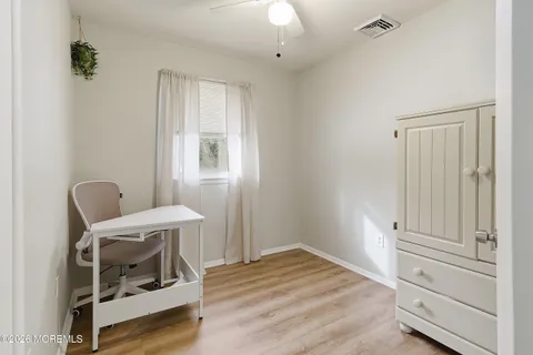 a view of a hallway with wooden floor and workspace