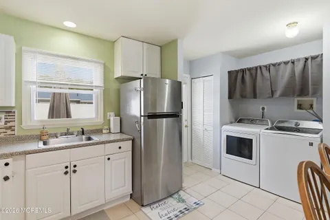 a kitchen with a sink cabinets stainless steel appliances and a window