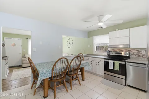 a kitchen with granite countertop white cabinets and stainless steel appliances