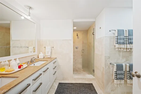 a bathroom with a double vanity sink toilet mirror and shower