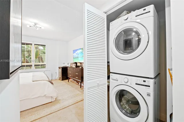 a large white bed sitting in a room next to a large window