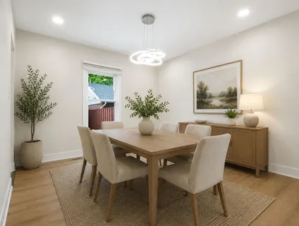 a dining room with furniture and potted plants