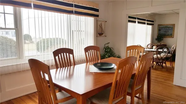 a view of a livingroom and dining room with furniture wooden floor and a potted plant