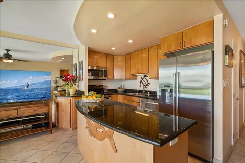 a kitchen with stainless steel appliances granite countertop a sink a stove and a refrigerator