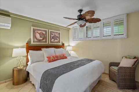 a bedroom with a bed ceiling fan and a window